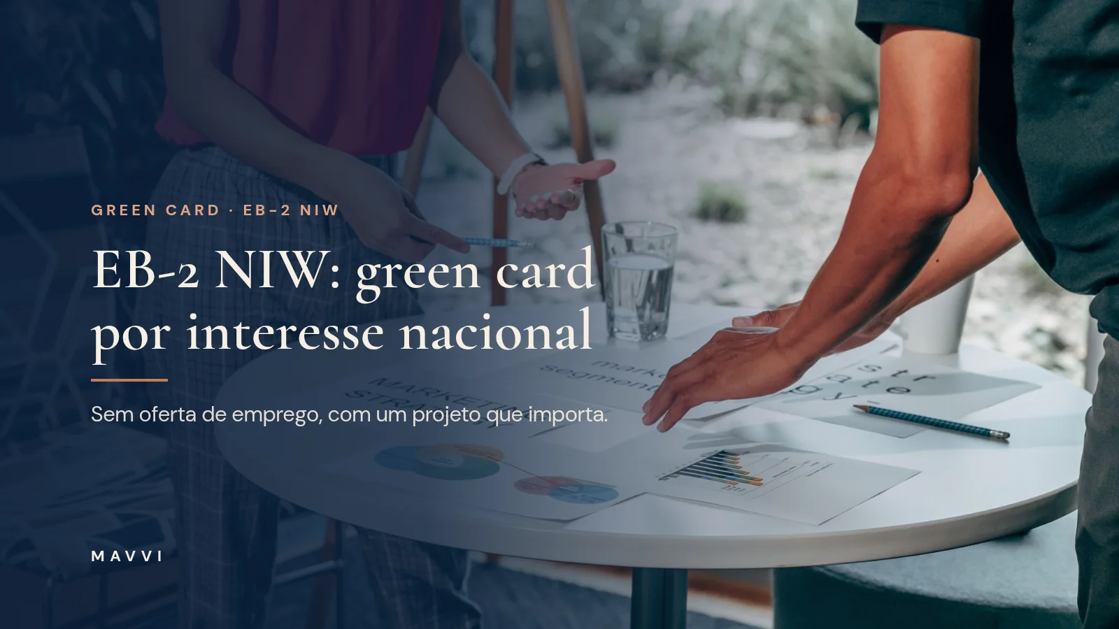 Duas pessoas trabalhando juntas numa mesa com papéis e laptop, planejando estratégia