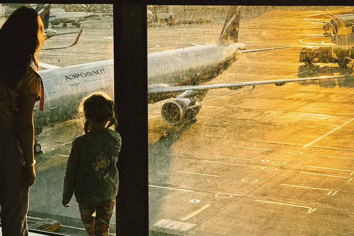 Família olhando os aviões no aeroporto, planejando morar nos EUA de forma permanente